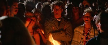 Movie still from “The Lost Boys” (1987), directed by Joel Schumacher – A group of people standing around a fire; Medium shot, Low angle