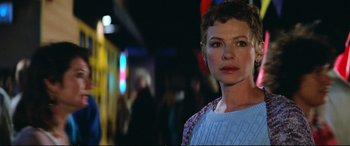 Movie still from “The Lost Boys” (1987), directed by Joel Schumacher – A person wearing a sweater near a building; Close Up shot, Over the shoulder angle