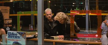 Movie still from “The Lost Boys” (1987), directed by Joel Schumacher – A man and a woman are looking at a book; Medium shot, Over the shoulder angle