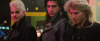 Movie still from “The Lost Boys” (1987), directed by Joel Schumacher – A man with long black hair wearing a leather jacket; Close Up shot, Over the shoulder angle
