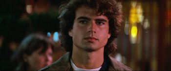 Movie still from “The Lost Boys” (1987), directed by Joel Schumacher – A person wearing a jacket and looking at the camera; Close Up shot, Over the shoulder angle