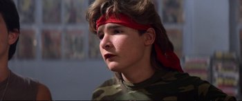 Movie still from “The Lost Boys” (1987), directed by Joel Schumacher – A man with a red bandanna on his head; Close Up shot, Low angle
