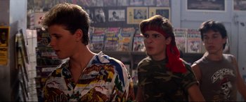 Movie still from “The Lost Boys” (1987), directed by Joel Schumacher – Two young men are standing in a room; Close Up shot, Over the shoulder angle
