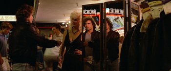 Movie still from “The Lost Boys” (1987), directed by Joel Schumacher – A man and a woman standing next to each other in front of a mirror; Medium shot, Over the shoulder angle