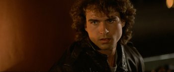 Movie still from “The Lost Boys” (1987), directed by Joel Schumacher – A person wearing a leather jacket; Close Up shot, Over the shoulder angle