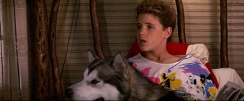 Movie still from “The Lost Boys” (1987), directed by Joel Schumacher – A boy and a dog sitting next to each other; Close Up shot, High angle