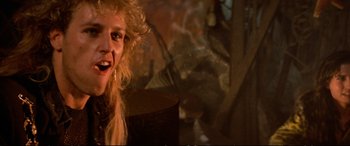 Movie still from “The Lost Boys” (1987), directed by Joel Schumacher – A person with curly blonde hair; Close Up shot, Over the shoulder angle