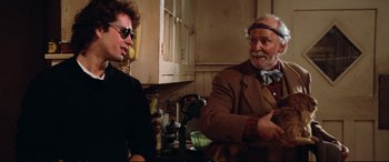 Movie still from “The Lost Boys” (1987), directed by Joel Schumacher – Two men are sitting in a kitchen talking to each other; Medium shot, Over the shoulder angle