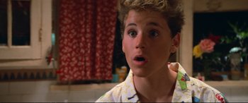 Movie still from “The Lost Boys” (1987), directed by Joel Schumacher – A young man with a surprised look on his face; Close Up shot, High angle