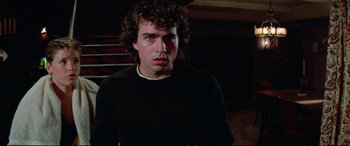 Movie still from “The Lost Boys” (1987), directed by Joel Schumacher – A man with curly brown hair wearing a black shirt; Close Up shot, Low angle