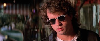 Movie still from “The Lost Boys” (1987), directed by Joel Schumacher – A person wearing sunglasses; Close Up shot, Low angle