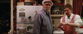 Movie still from “The Lost Boys” (1987), directed by Joel Schumacher – An older man standing in front of a refrigerator in a kitchen; Medium shot, Over the shoulder angle