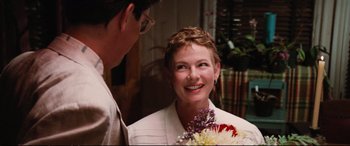 Movie still from “The Lost Boys” (1987), directed by Joel Schumacher – A man and a woman smiling at each other holding flowers; Close Up shot, Over the shoulder angle