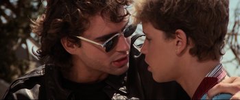 Movie still from “The Lost Boys” (1987), directed by Joel Schumacher – Two young men are talking to each other; Close Up shot, Over the shoulder angle