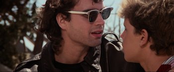 Movie still from “The Lost Boys” (1987), directed by Joel Schumacher – A person wearing sunglasses; Close Up shot, Over the shoulder angle