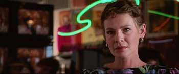 A person wearing a dress with a neon light in the background