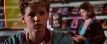 Movie still from “The Lost Boys” (1987), directed by Joel Schumacher – A young man is looking into the camera; Close Up shot, Over the shoulder angle