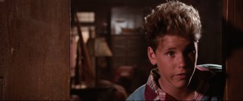 Movie still from “The Lost Boys” (1987), directed by Joel Schumacher – A young boy with a messy mohawk haircut; Close Up shot, Low angle