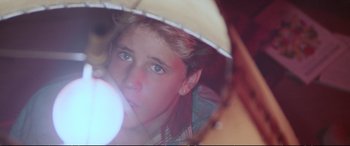 Movie still from “The Lost Boys” (1987), directed by Joel Schumacher – A young boy looking into a mirror with his reflection in the mirror; Close Up shot, Over the shoulder angle