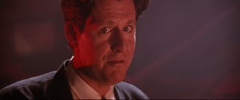Movie still from “The Lost Boys” (1987), directed by Joel Schumacher – A person wearing a suit and tie; Close Up shot, Low angle