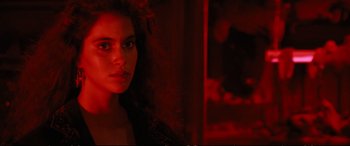 Movie still from “The Lost Boys” (1987), directed by Joel Schumacher – A woman in a red room with a cat; Close Up shot, Over the shoulder angle