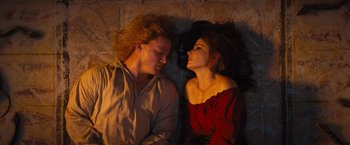 Movie still from “The Lost City” (2022), directed by Aaron Nee – A man and a woman laying on the ground; Medium shot, Overhead angle