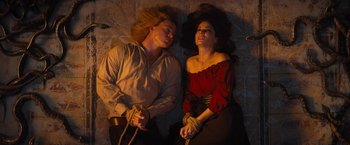 Movie still from “The Lost City” (2022), directed by Aaron Nee – A man and a woman tied to the ground; Medium shot, Overhead angle