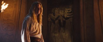 Movie still from “The Lost City” (2022), directed by Aaron Nee – A woman standing in front of an egyptian mural; Medium shot, Over the shoulder angle