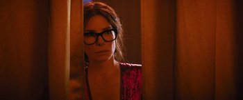 Movie still from “The Lost City” (2022), directed by Aaron Nee – A woman wearing glasses looking into a mirror; Close Up shot, Over the shoulder angle
