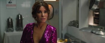 Movie still from “The Lost City” (2022), directed by Aaron Nee – A woman in a purple dress is standing in a room; Close Up shot, Over the shoulder angle