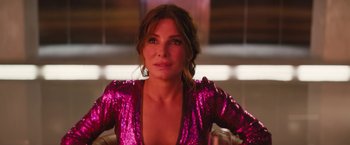 Movie still from “The Lost City” (2022), directed by Aaron Nee – A person wearing a pink dress; Close Up shot, Over the shoulder angle