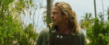 Movie still from “The Lost City” (2022), directed by Aaron Nee – A person with long blonde hair; Close Up shot, Over the shoulder angle