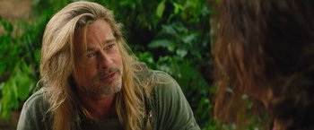Movie still from “The Lost City” (2022), directed by Aaron Nee – A person with long blonde hair; Close Up shot, Over the shoulder angle
