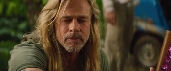 Movie still from “The Lost City” (2022), directed by Aaron Nee – A man with long blonde hair and a beard; Close Up shot, Over the shoulder angle