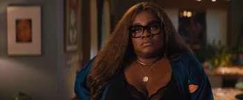 Movie still from “The Lost City” (2022), directed by Aaron Nee – A person wearing glasses and a necklace; Close Up shot, Over the shoulder angle