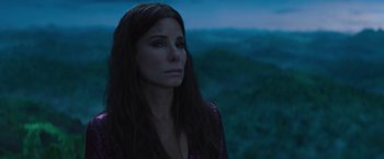 Movie still from “The Lost City” (2022), directed by Aaron Nee – A beautiful woman with long hair looking off into the distance; Close Up shot, High angle