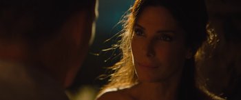 Movie still from “The Lost City” (2022), directed by Aaron Nee – A woman's face in the dark; Close Up shot, Over the shoulder angle