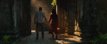 Movie still from “The Lost City” (2022), directed by Aaron Nee – A man and a woman holding hands while walking; Wide shot, Over the shoulder angle