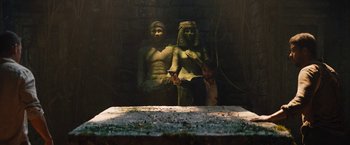 Movie still from “The Lost City” (2022), directed by Aaron Nee – A statue of a man and a woman sitting on a bench; Wide shot, High angle