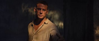 Movie still from “The Lost City” (2022), directed by Aaron Nee – A person wearing a white shirt; Close Up shot, Over the shoulder angle