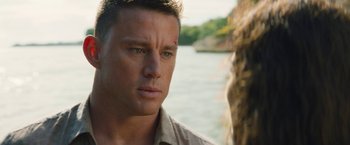 Movie still from “The Lost City” (2022), directed by Aaron Nee – A person near a body of water; Close Up shot, Over the shoulder angle
