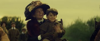 Movie still from “The Lost City of Z” (2016), directed by James Gray – A woman and a boy in a hat and coat; Medium shot, Low angle