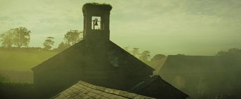 Movie still from “The Lost City of Z” (2016), directed by James Gray – A bell tower on top of an old brick building; Extreme Wide shot, Low angle
