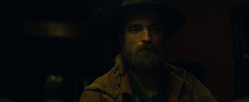 Movie still from “The Lost City of Z” (2016), directed by James Gray – A man with a long beard wearing a hat; Close Up shot, Over the shoulder angle
