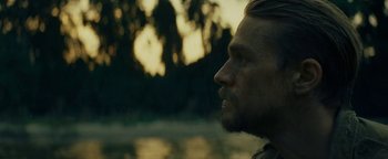 Movie still from “The Lost City of Z” (2016), directed by James Gray – A person's face near a body of water; Close Up shot, Over the shoulder angle