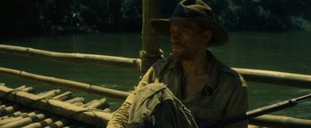 Movie still from “The Lost City of Z” (2016), directed by James Gray – A man sitting in a boat on a river; Medium shot, High angle