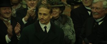 Movie still from “The Lost City of Z” (2016), directed by James Gray – A man in a black suit and a woman in a black hat; Close Up shot, Low angle