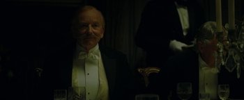Movie still from “The Lost City of Z” (2016), directed by James Gray – An old man in a tuxedo standing in front of a mirror; Close Up shot, Over the shoulder angle