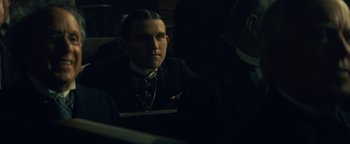 Movie still from “The Lost City of Z” (2016), directed by James Gray – A man in a suit and tie sitting in a dark room; Close Up shot, Low angle