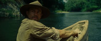 Movie still from “The Lost City of Z” (2016), directed by James Gray – A man wearing a hat sitting on a boat in the water; Close Up shot, Over the shoulder angle